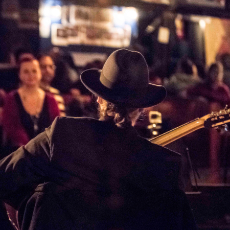 A mirror shot of Marc Wencelius seen from the back and towards the crowd at the Club Balattou. Musicos Productions. Photo credited to Peter Graham